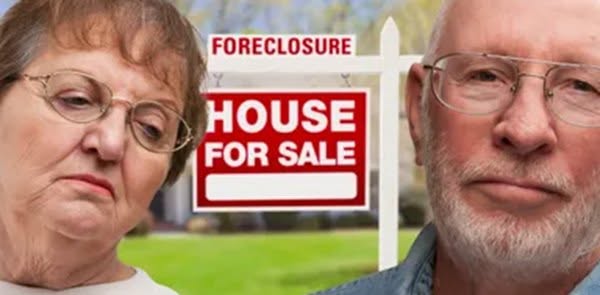 Senior veteran couple standing in front of their home